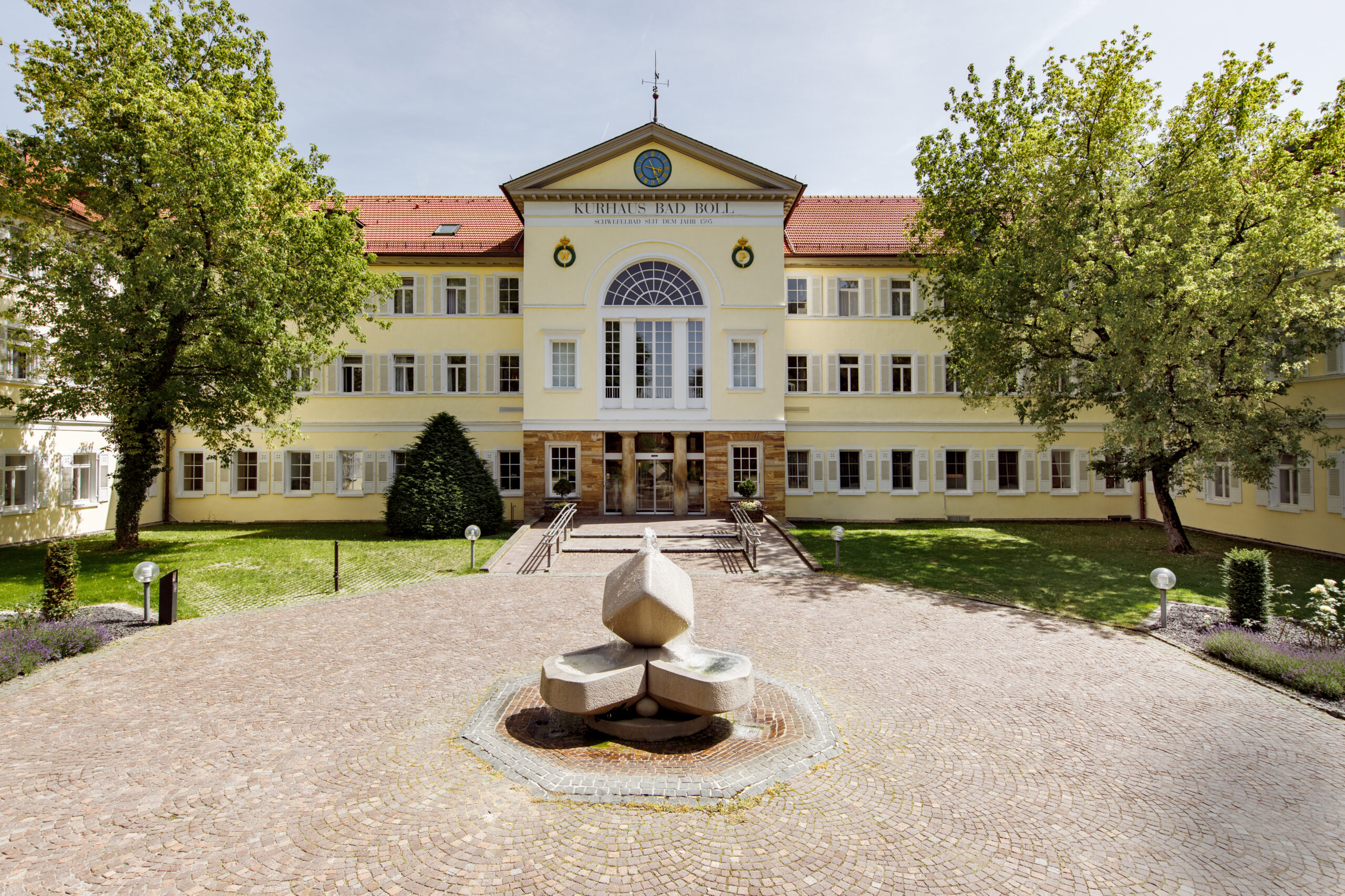 Haupteingang der Rehaklinik mit Brunnenplaza im Vordergrund